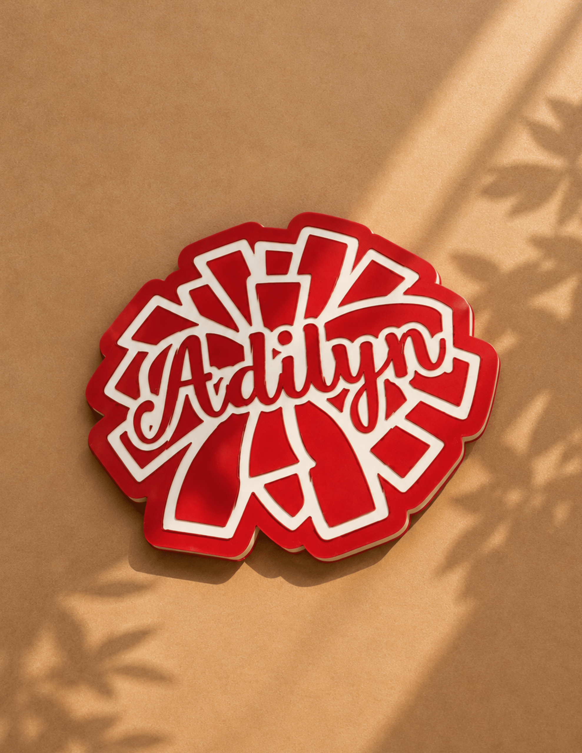 Personalized cheer pin with custom name in a layered red and white pom-pom design.
