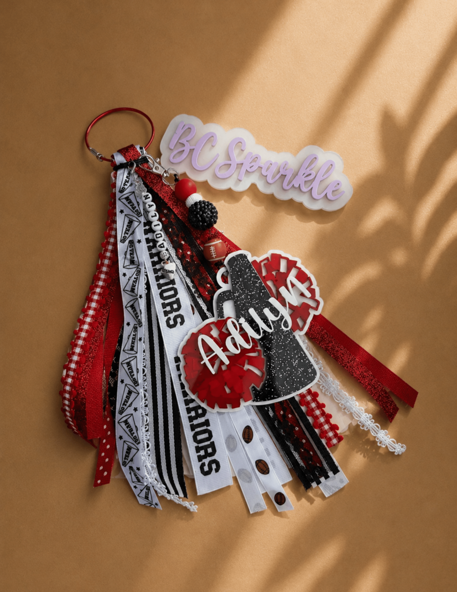 Personalized beaded cheer bag tag with custom ribbons, name charm, and cheer-themed accents.