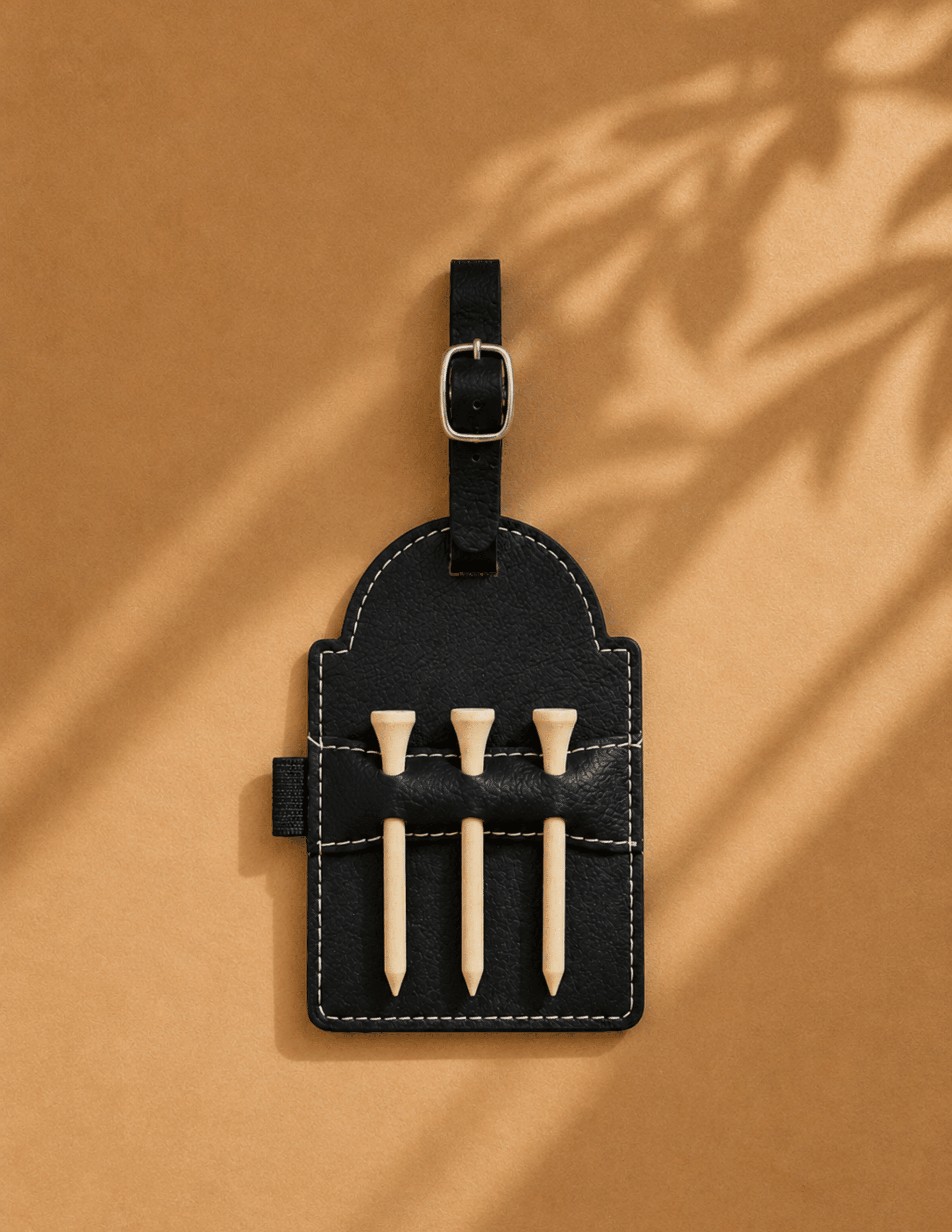Personalized leather golf tee holder with wooden tees and adjustable buckle strap.
