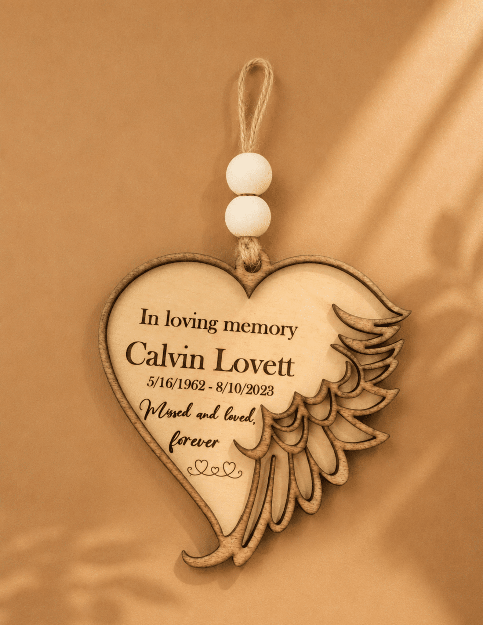 Personalized wooden heart memorial ornament with angel wing, custom name, dates, and remembrance message.