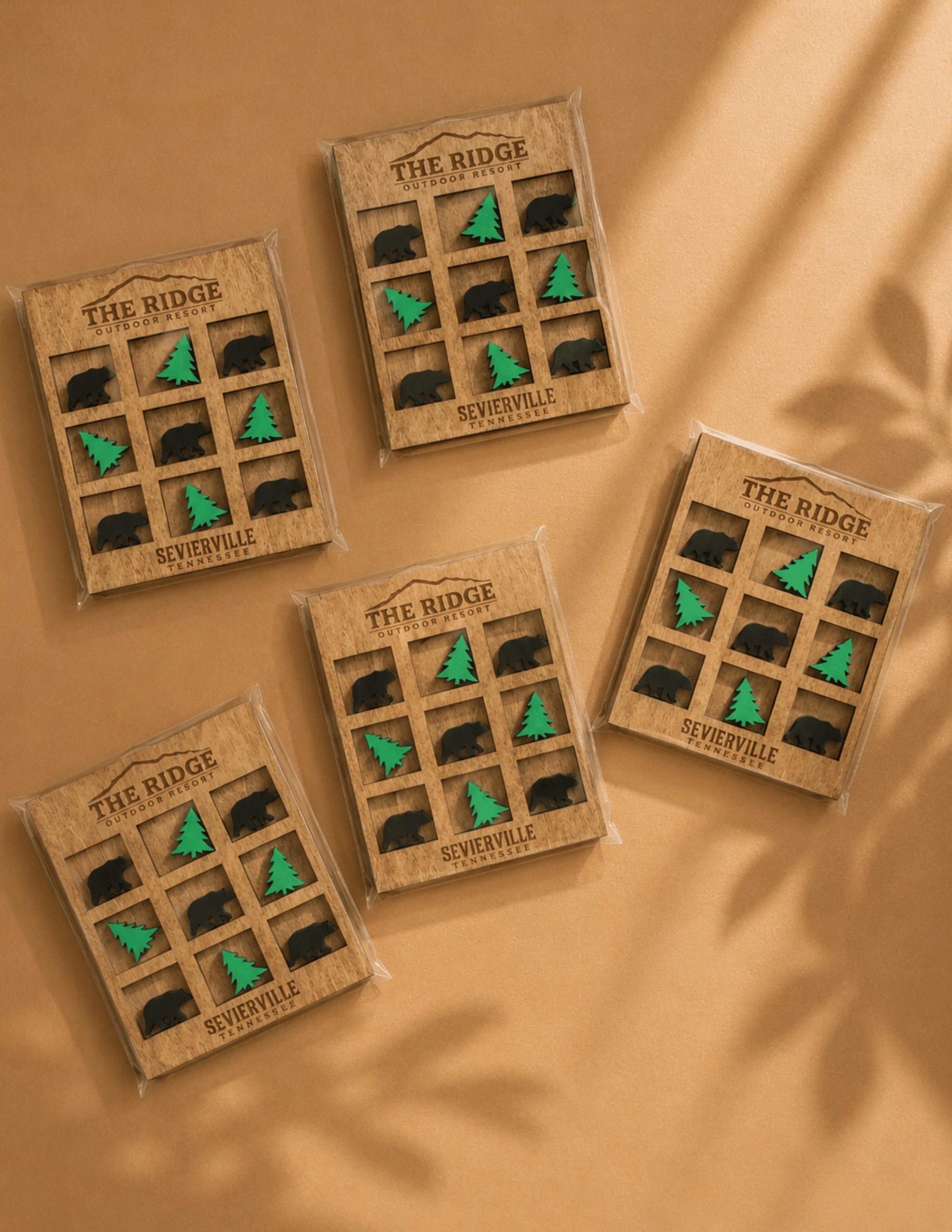 Personalized wooden tic tac toe game with engraved logo and custom bear and pine tree game pieces.
