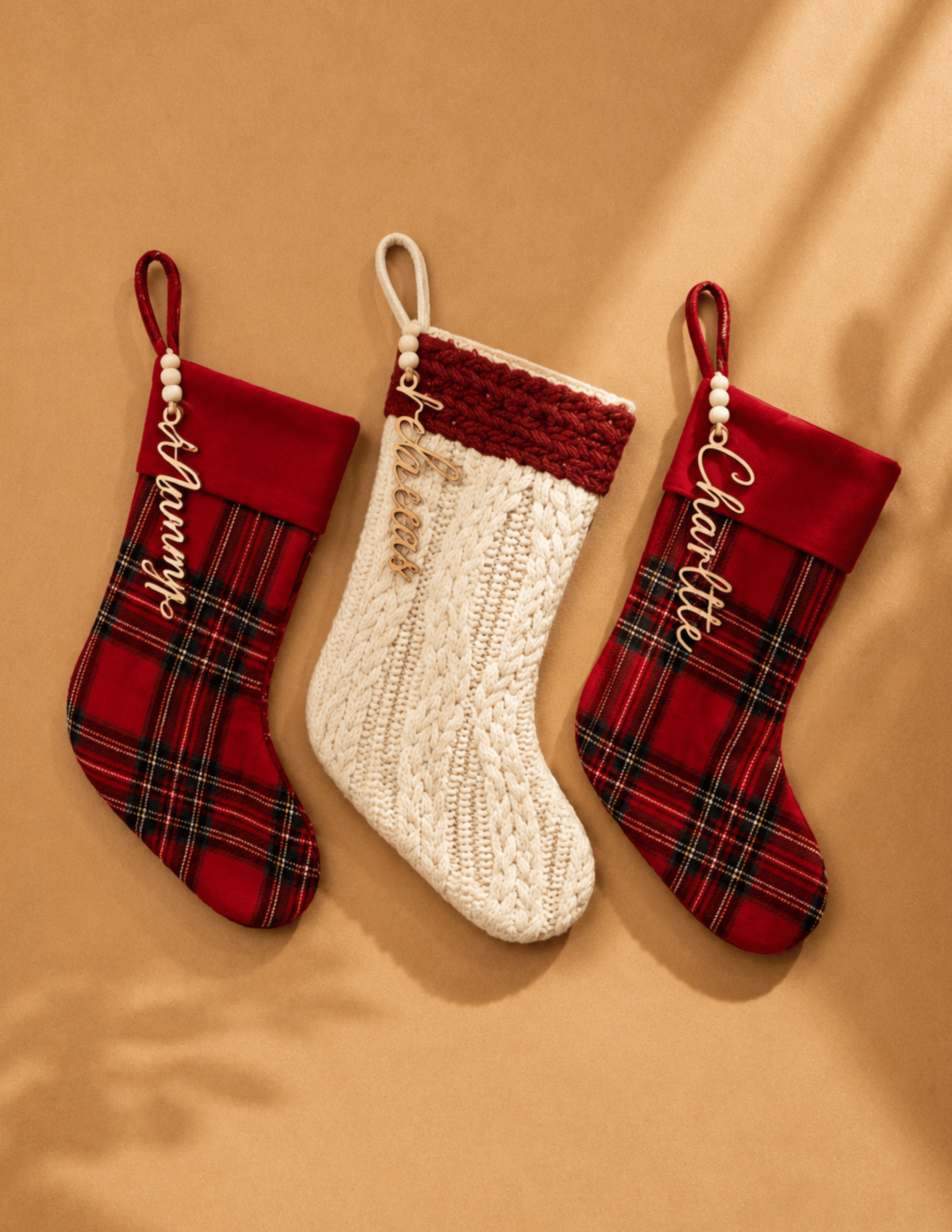 Personalized script name stocking tags attached to red plaid and knit Christmas stockings.