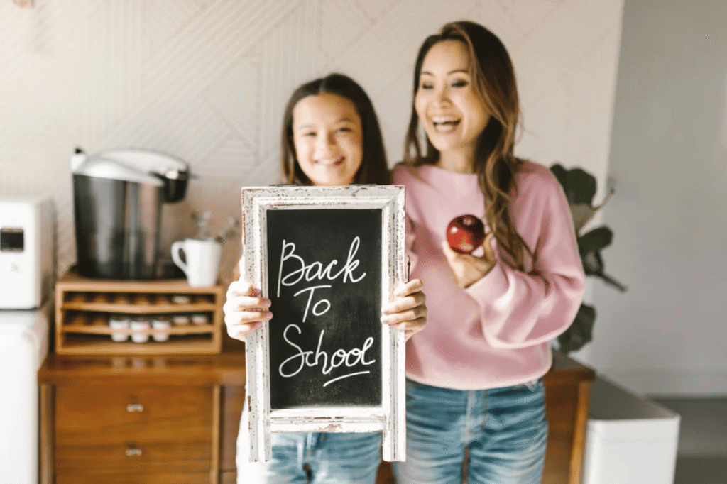 Mother and daughter holding a back-to-school sign, celebrating personalized gift ideas for the new school year.