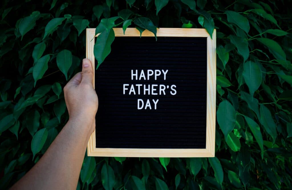 Happy Father's Day sign surrounded by green leaves