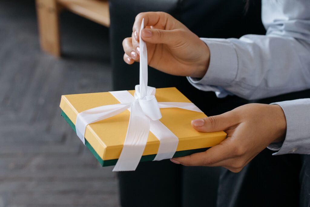 Corporate gift ideas for customers featuring a professionally wrapped gift box with a white ribbon.